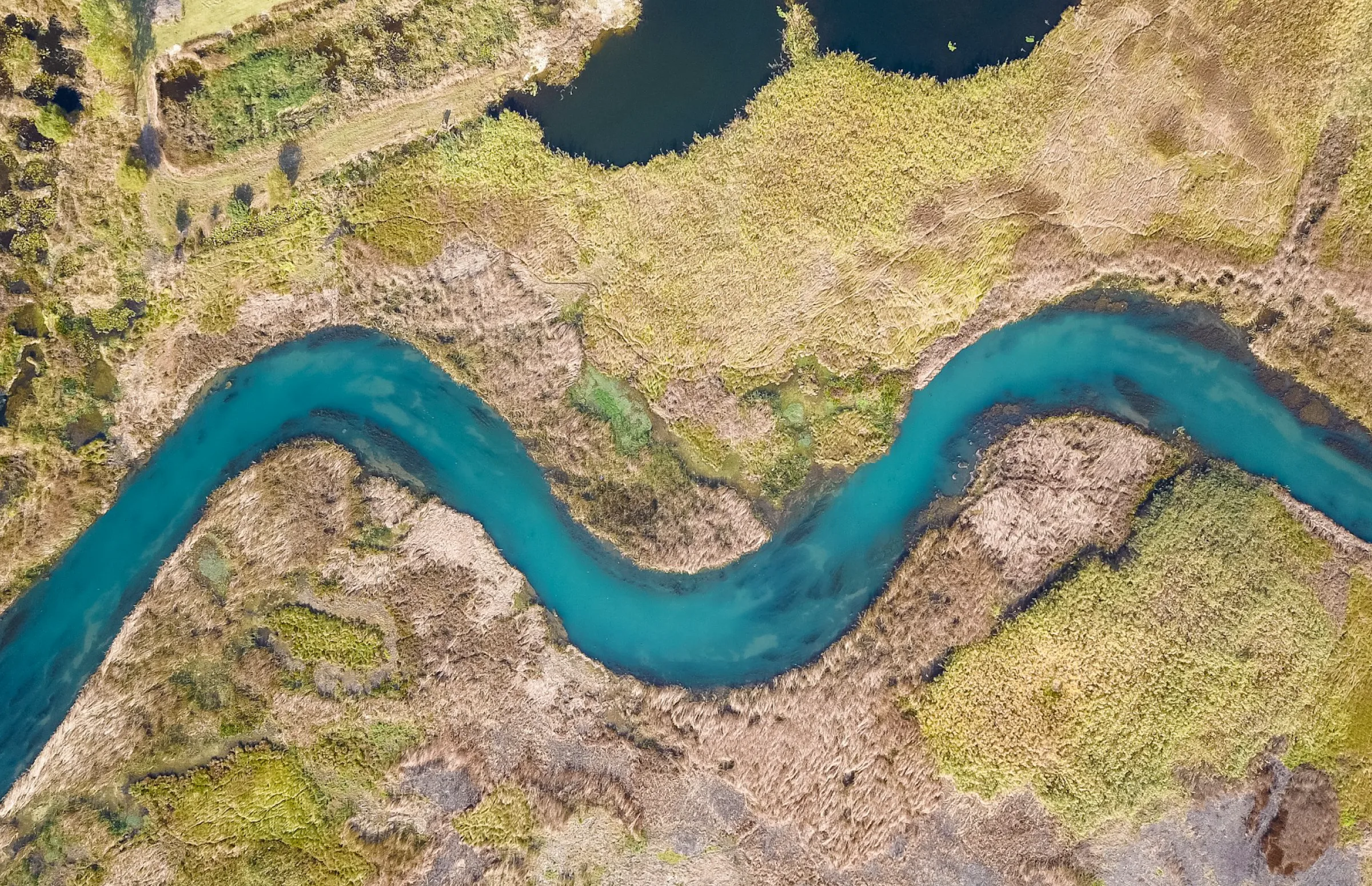 Aerial view of a winding river through green countryside